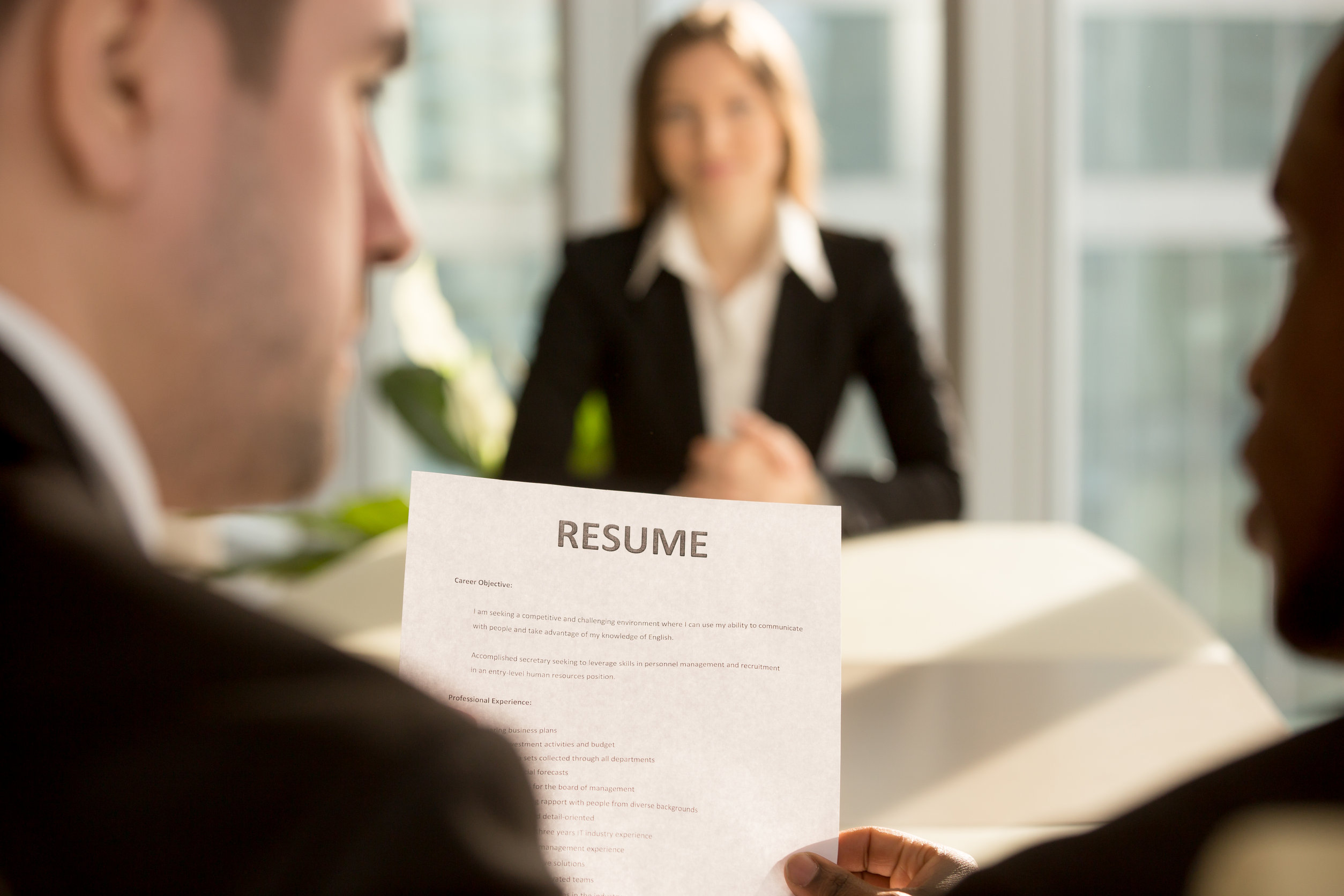 Multiracial employers making hiring decision, focus on resume, j